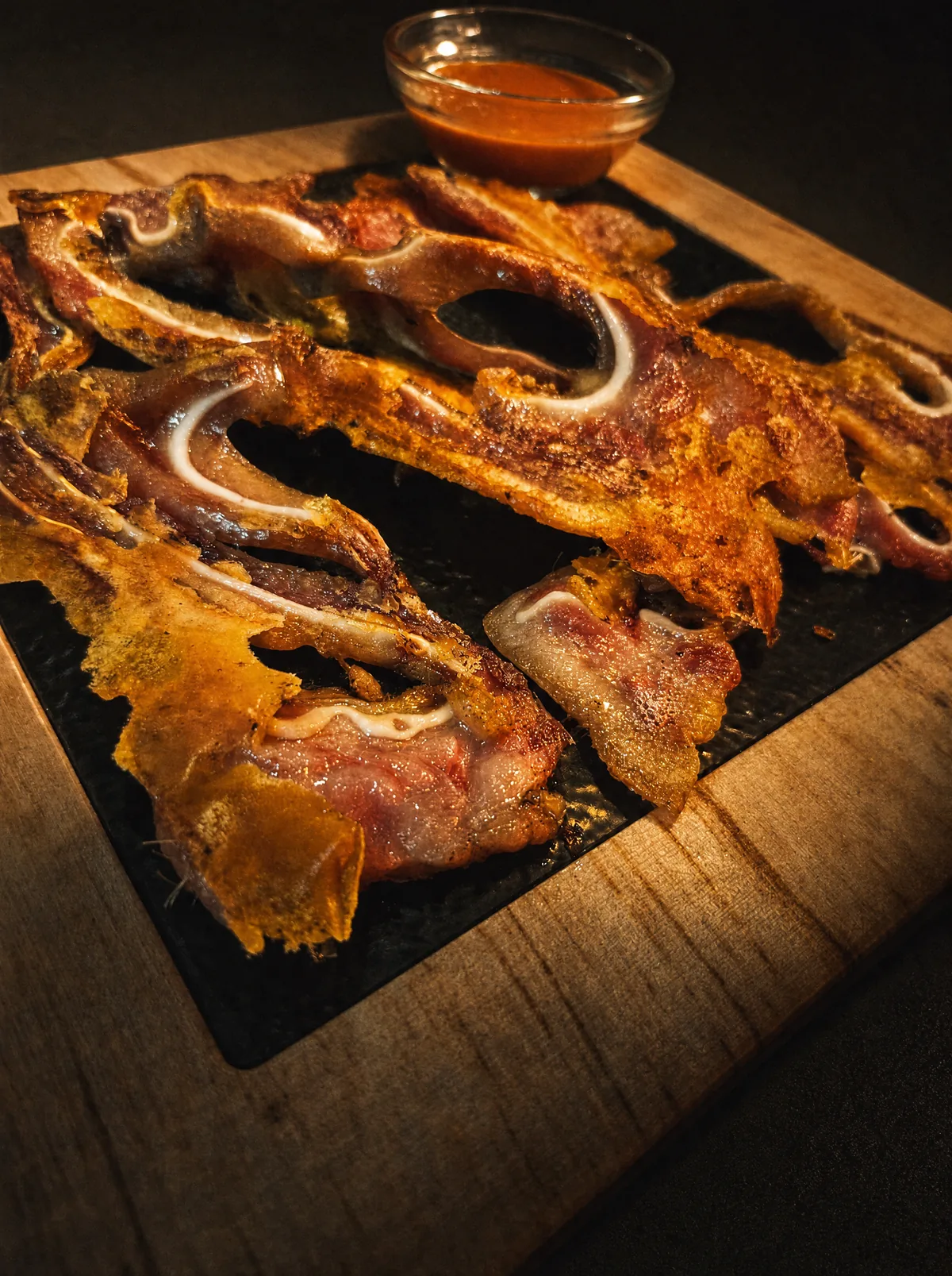 Chuletillas de oreja a la plancha con salsa brava en tabla de madera